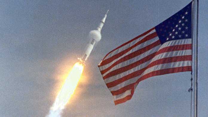 US-Flagge, im Hintergrund startende Rakete