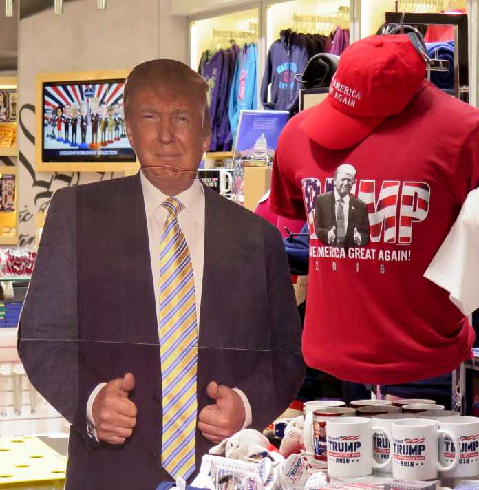Pappfigur Trumps neben Trump-T-Shirt