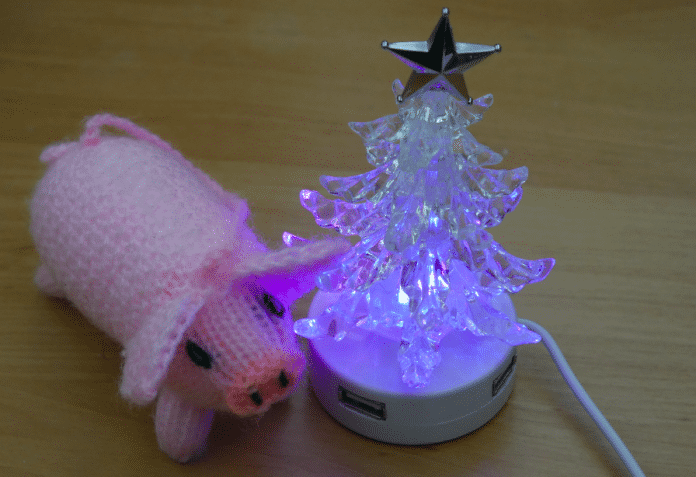 Auch ein Weihnachtsbaum: Das Häkelschwein bewundert die Digitalinstallation in der analogen Realität