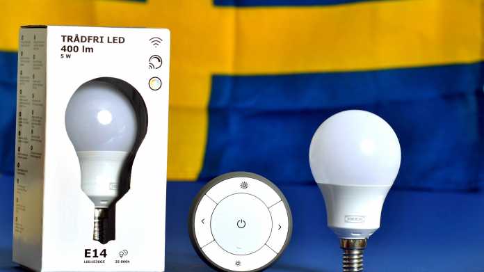 Zwei Ikea-Tradfri-Lampen und eine Fernbedienung vor der blau-gelben schwedischen Flagge