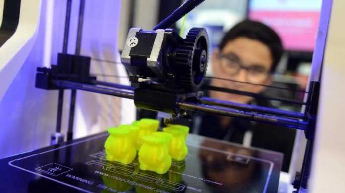 Person hinter 3D-Drucker