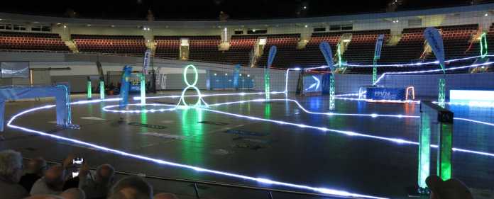 Wettkampfarena des INTERcopter Racing Cup 2017 in der abgedunkelten Halle mit illuminiertem Parcour