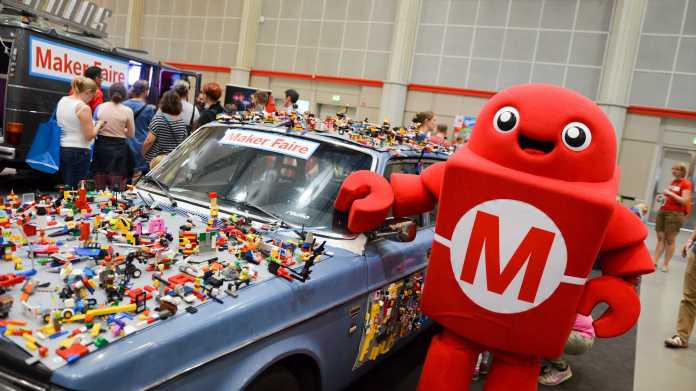 Ein roter Makey neben einem Auto, das mit Lego beklebt ist