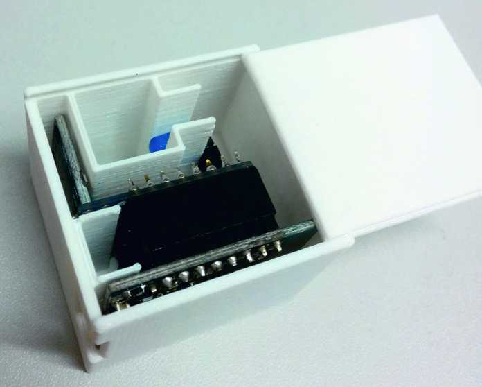 Blick in ein weißes Kistchen mit mehreren Innenwänden, an denen elektronische Bauteile befestigt sind