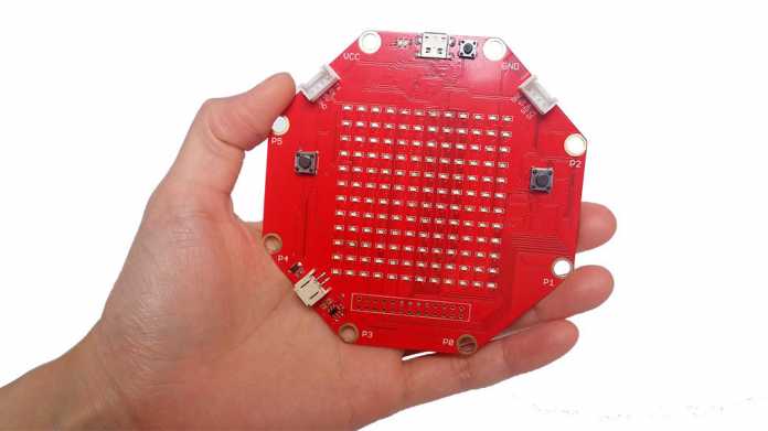 Eine Hand hält eine rote Platine mit acht Seiten, auf der 144 LEDs verbaut sind