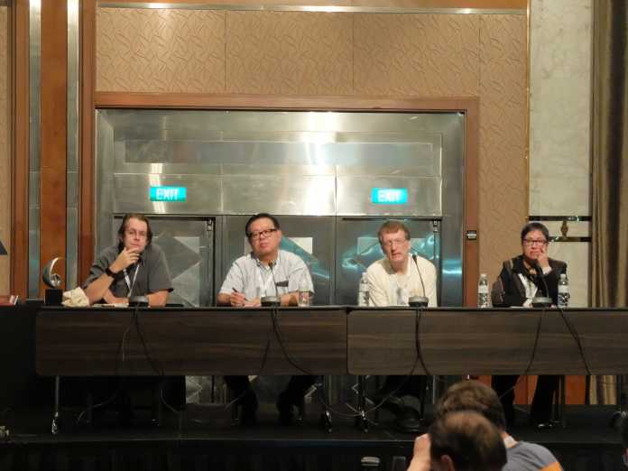 Dunkler Ausblick vor hellem Hintergrund: Brian Trammell, Jun Murai, Henning Schulzrinne und Monique Morrow beim 100. IETF-Treffen.