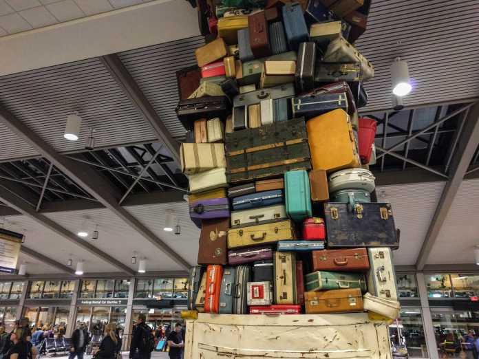 Bis zur Decke aufgetürmte Koffer in einer Flughafenhalle 