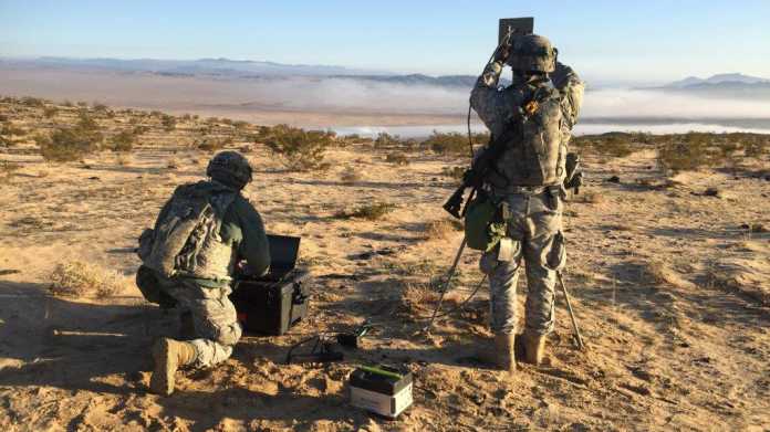2 Soldaten in Tarnkleidung hantieren mit technischen Geräten