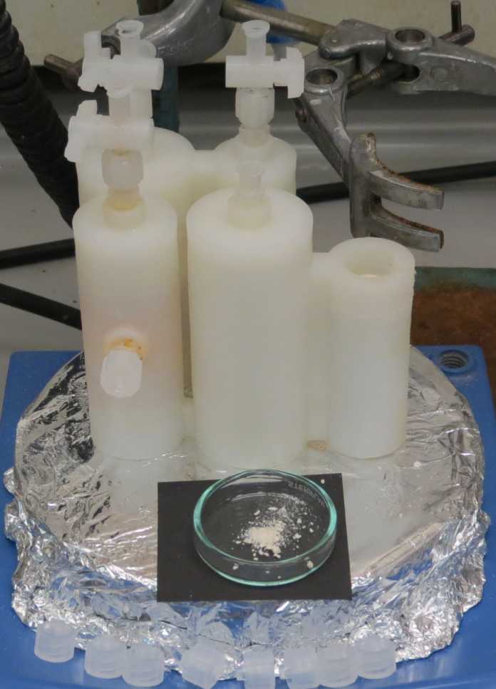 Auf einer silbernen Schale stehen mehrere weiße Zylinder, die miteinander verbunden sind. Davor liegt in einer Glasschale ein helles Pulver.