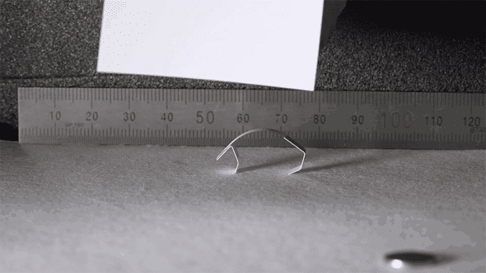 Ein gebogener Metallstreifen vor einem Zentimetermaß