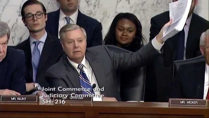 Senator Graham hält einen dicken Stapel Papier hoch