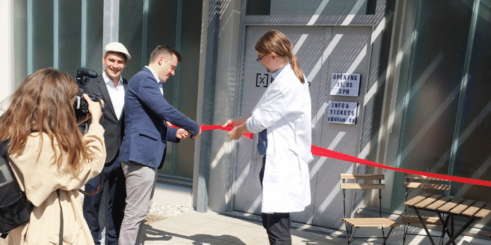 Eröffnung der Bio.kitchen in München mit feierlichem Zerschneiden des roten Bands vor der Labortür