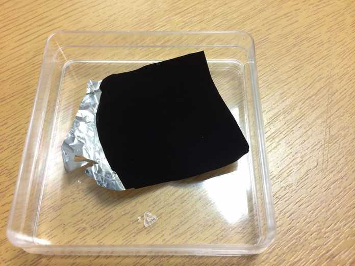 Mit Vantablack beschichtete Alufolie - Das schwarze Stück wirkt wie mit Photoshop ausgeschnitten, da es keinerlei Informationen über die Beschaffenheit des Materials freigibt.