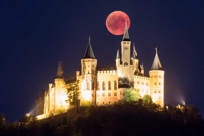 Wolkenfreier Himmel über dem Horizont ermöglichten es den Mond hinter der Burg Hohenzollern zu fotografieren.