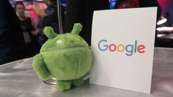 Grüner Plüsch-Androide neben Schild &quot;Google&quot;