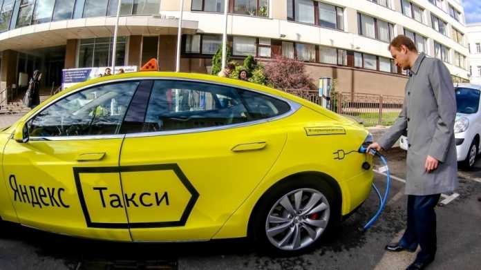 Gelber Tesla mit russischer Aufschrift &quot;Yandex Taxi&quot;