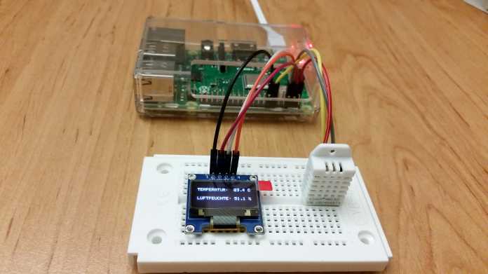 Raspberry Pi neben Breadboard mit Temperatursensor und OLED, auf dem die aktuelle Temperatur angezeigt wird.