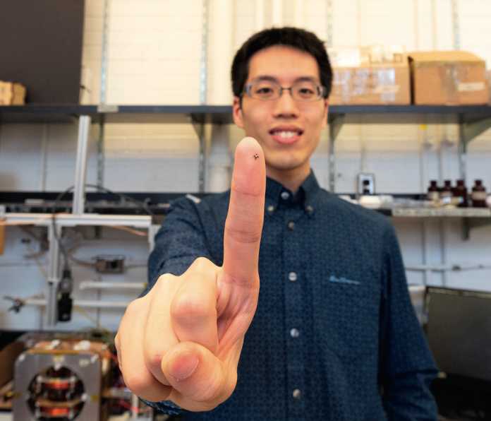 Wissenschaftler Tianqi Xu zeigt auf seiner Fingerkuppe einen Mikroroboter-Greifer, mit dem die Forscher in einer Mikrofabrikation kleinste Teile manipulieren.