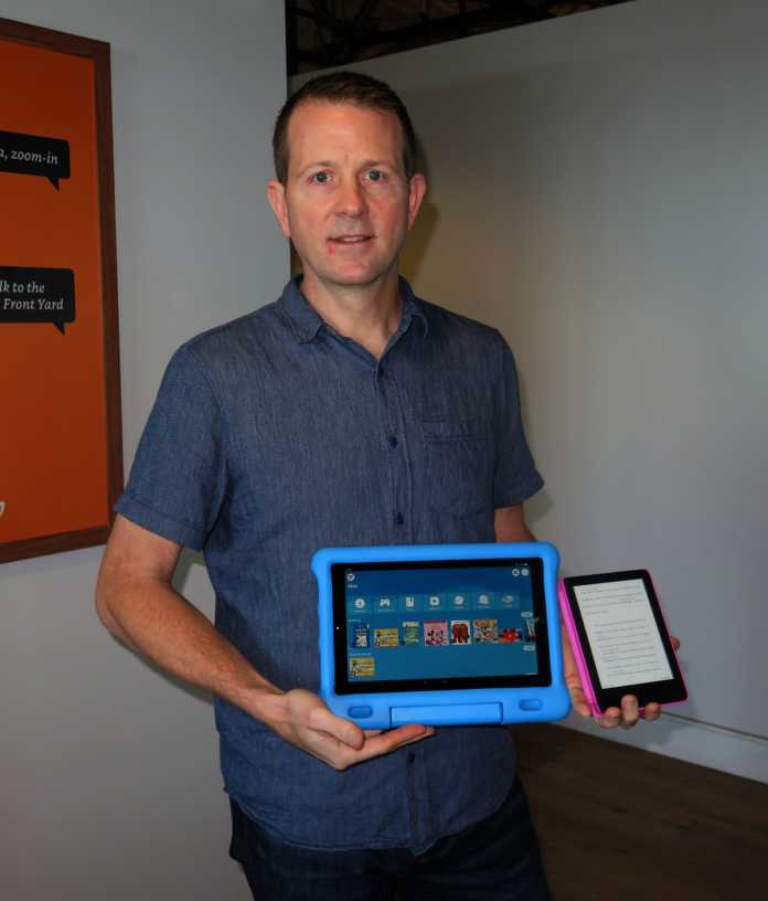 Kurt Beidler hält ein Tablet und einen E-Reader in bunten Hüllen