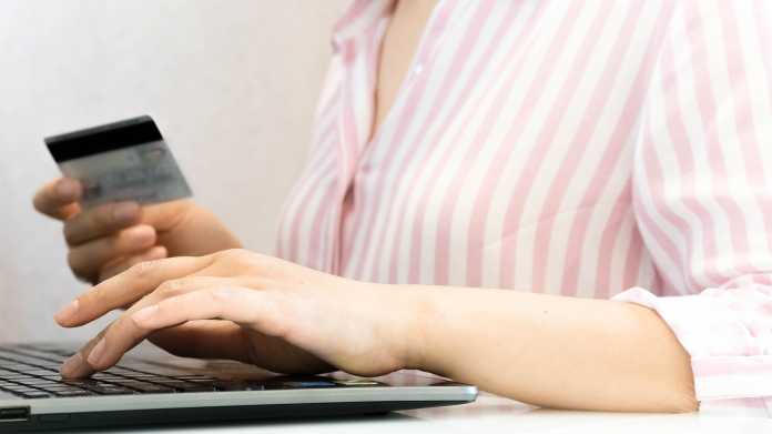 Eine Frau bezahlt im Internet mit ihrer Kreditkarte