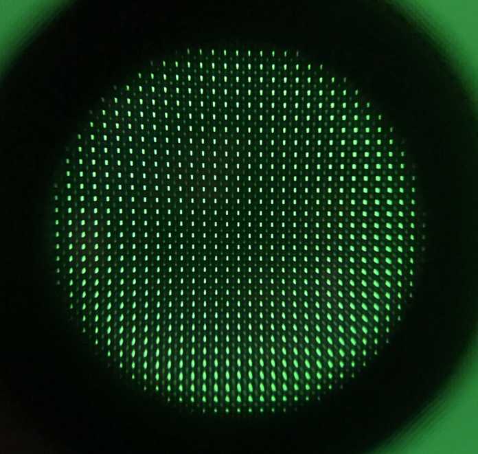 Unterm Mikroskop sieht man die grünen Pixel des VA-Panels, jeweils vier bilden ein Cluster: Das Pixel links oben leuchtet hell, eins nur schwach (rechts unten) und zwei sehr schwach (rechts oben und links unten). Die blauen und roten Subpixel in den vier Bildpunkten sind komplett aus.
