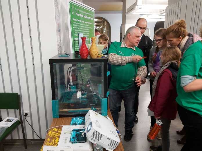 Einer der Projektingenieure von 3dk.berlin zeigt interessierten Schülerinnen die Möglichkeiten des 3D-Drucks während der Oberschulmesse in Berlin Spandau.
