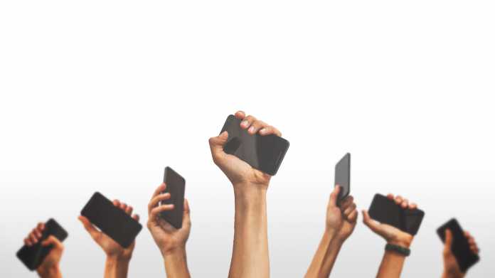 Mehrere Hände recken Smartphones empor