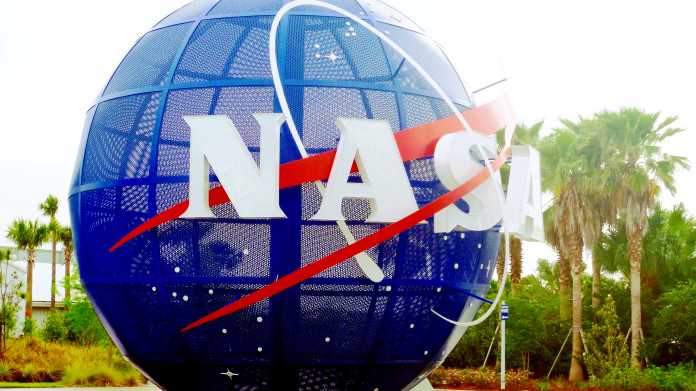 Blaue Kugel mit NASA-Schriftzug, dahinter Palmen
