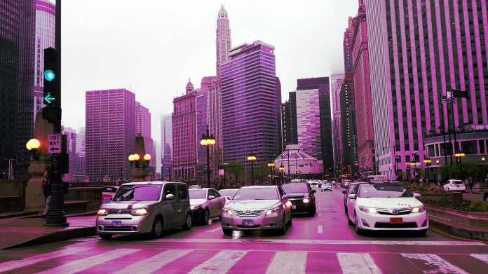 Farbverfälschte Aufnahme zeigt eine Grüne Ampel und mehrere Autos vor Hochhäusern Chicagos