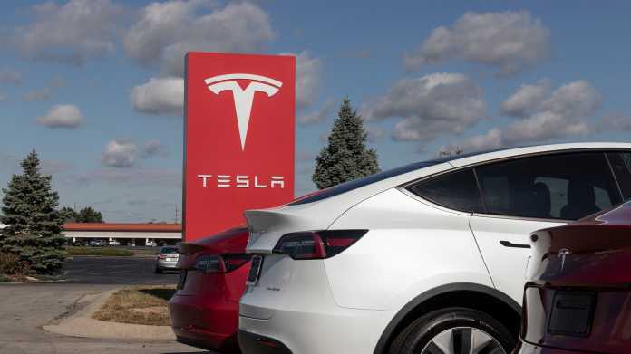 Tesla-Schild, davor das Heck eines Tesla-Autos