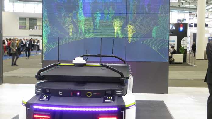 Lidar-Präsentation auf einem Messestand: Autoatrappe, darauf ein Lidar - auf einem Bildschirm sind die vom Lidar erfassten Punkte der Umgebung zu sehen