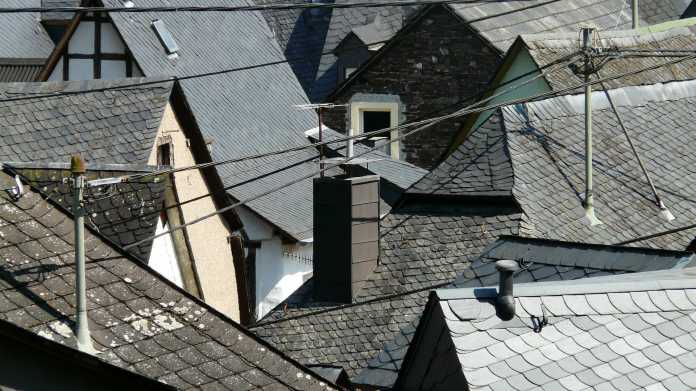Strommasten über den Dächern von Privathäusern