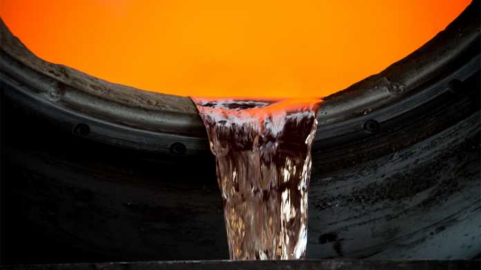 Flüssiges Metall läuft über den Rand eines Gefäßes, im Inneren ein leuchtendes Orange.