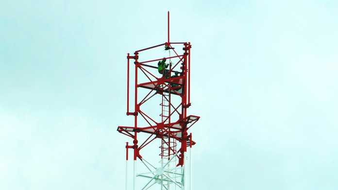 2 schwarze Arbeiter in der Spitze eines neuen Antennenturms