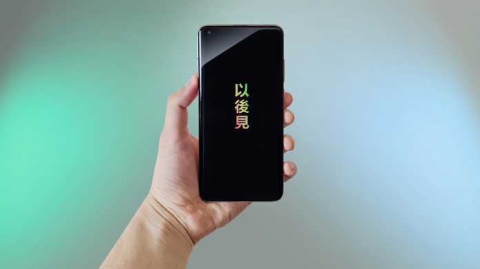 Handy mit chinesischen Symbolen gehalten von einer Hand