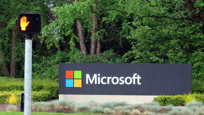 Schild "Microsoft" an Einfahrt zu Microsoft-Gelände, davor eine auf Rot stehende Fußgängerampel