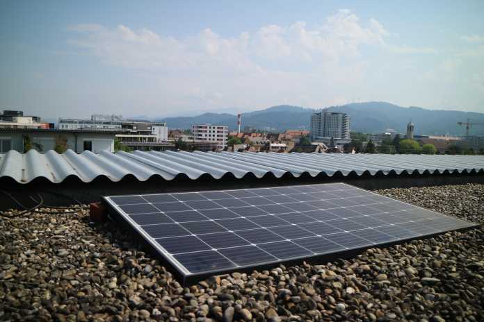 Solaranlage auf einem mit Kies bedeckten Flachdach.