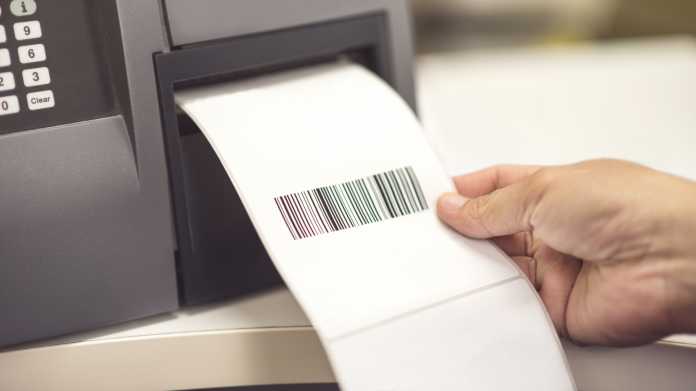 Ein Etikett mit einem Barcode wird aus einem Drucker entnommen.