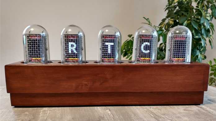 Fünf kleine Glaskuppeln stehen auf einer Holzleiste. In den Kuppeln sind jeweils TFT-Displays, drei sind an und zeigen: R T C.