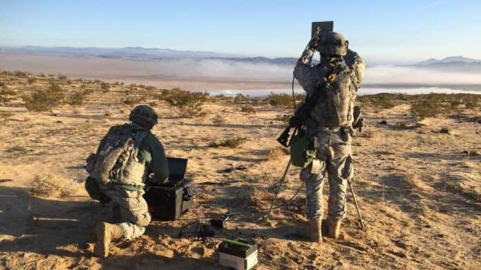 2 Soldaten in Tarnkleidung hantieren mit technischen Geräten