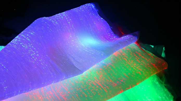 Vier Seidenstoffe, die in unterschiedlichen Farben fluoreszieren