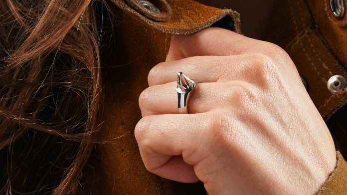 Eine weiße Hand trägt einen silbernen Ring mit Schraubendreher-Spitze.