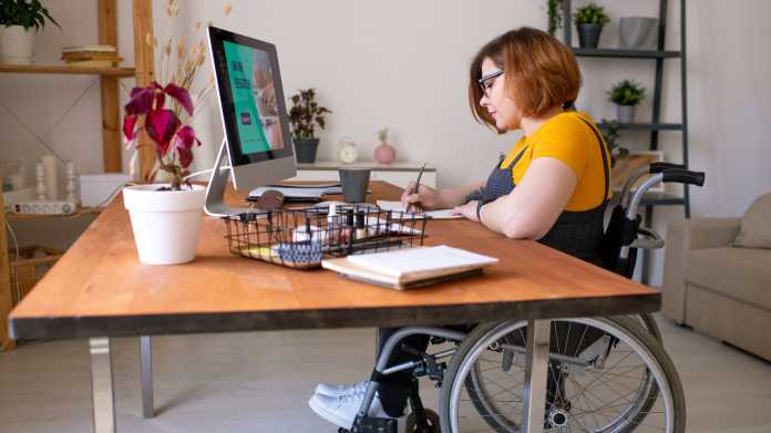 Young,Disable,Woman,In,Wheelchair,Making,Notes,In,Front,Of