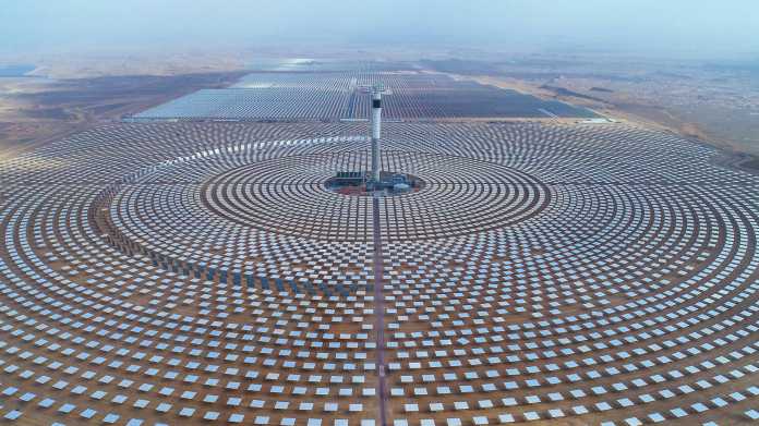 Das Solarkraftwerk Noor III im marokkanischen Ouarzazate besteht seit 2018 und leistet 150 Megawatt. Spiegel auf einer Fläche von fast 700 Hektar fokussieren das Sonnenlicht auf einen 240 Meter hohen Turm, wo Temperaturen von bis zu 700 Grad Dampf für eine Turbine erzeugen. Ein thermischer Speicher erlaubt es, auch nachts Strom zu erzeugen. , Foto: picture alliance / Photoshot