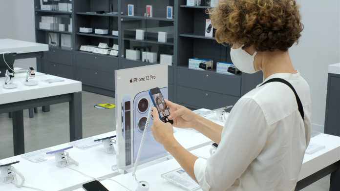 Eine Frau betrachtet ein iPhone im Apple Store