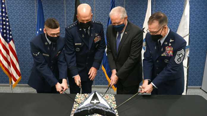 Vier uniformierte Männer nutzen kleine Schwerter um eine Torte mit Logo der US Space Force anzuschneiden
