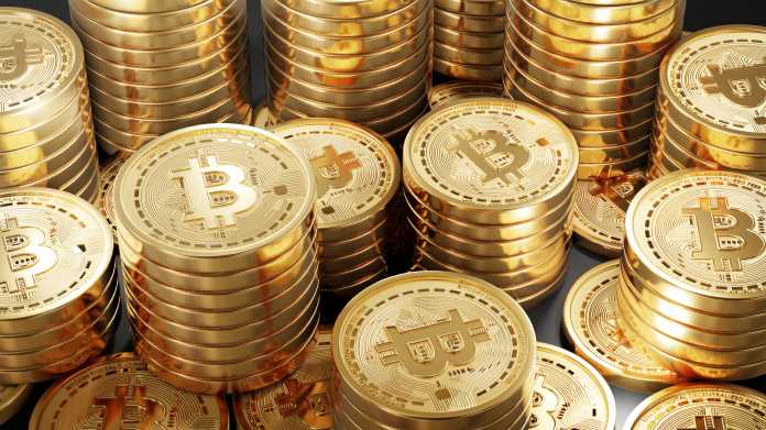 Stapelweise güldene Münzen mit aufgeprägtem Bitcoin-Logo