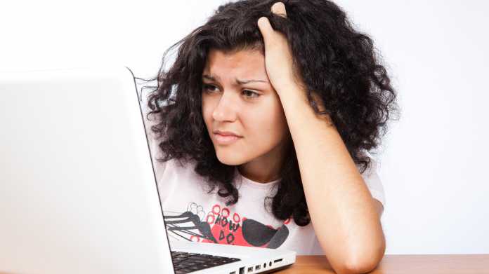 Eine Frau verzweifelt vor ihrem Laptop