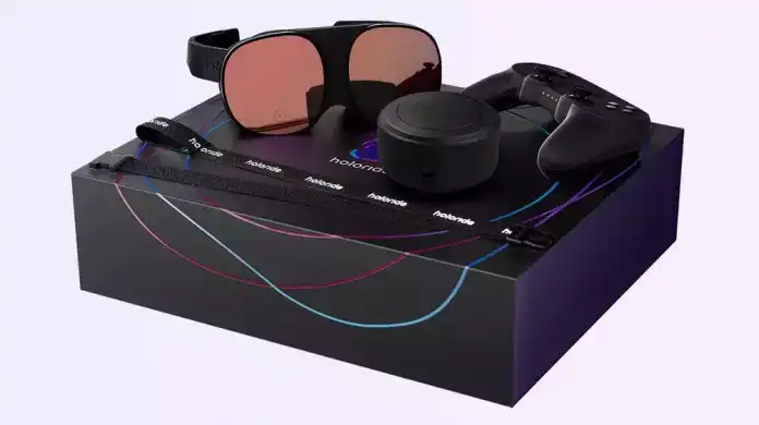 Auf einer schwarzen Schachtel liegen eine VR-Brille, ein Steuergerät und eine Art Puck, allesamt schwarz