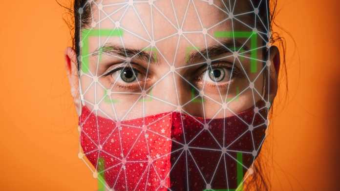 Symbolbild Gesichtserkennung: Eine Frau mit roter Maske ist mit Rasterpunkten übersäht